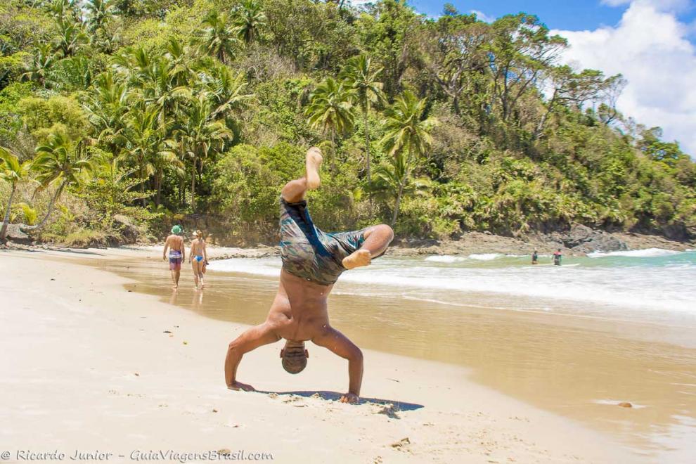 Imagem de um rapaz fazendo acrobacias na Praia da Engenhoca.